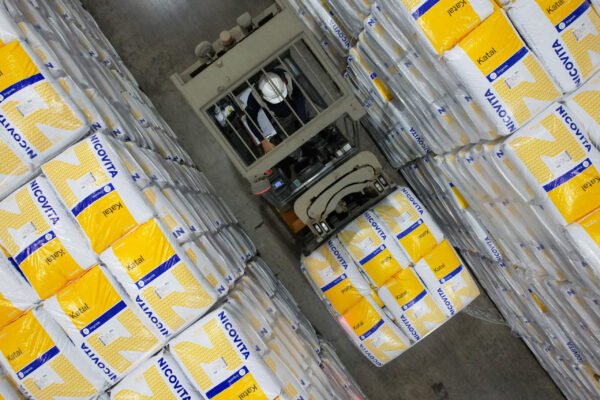 Instalación de producción de Vitapro con sacos de alimento, destacando reducción de emisiones en 2025