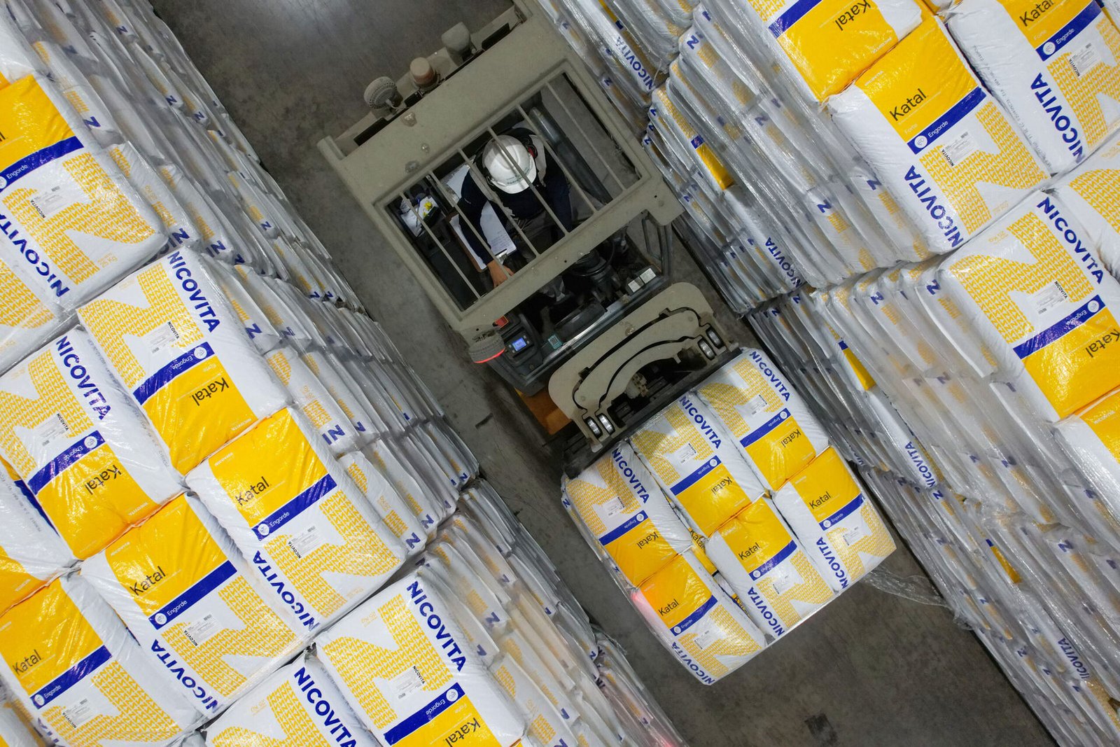 Instalación de producción de Vitapro con sacos de alimento, destacando reducción de emisiones en 2025